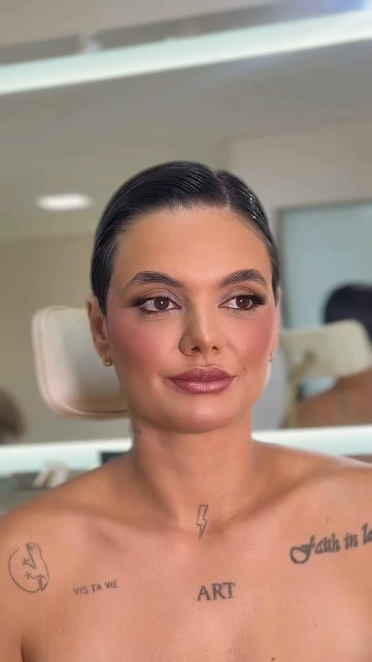 Retrato em vídeo, sem som: rosto de frente com blush marcado, delineado e lábios rosados, que se vira devagar para o lado.